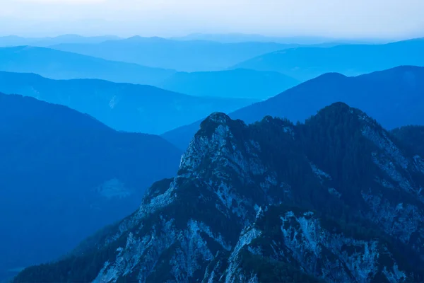 Εντυπωσιακή θέα του μπλε οροσειρές σιλουέτες και ομίχλη σε κοιλάδες. Julian Alps, Εθνικό Πάρκο Triglav, Σλοβενία. Θέα από το βουνό Slemenova, Sleme. — Φωτογραφία Αρχείου