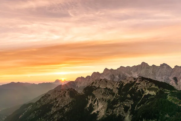 Increíble amanecer en las montañas. Luz de fondo Luz del sol con hermosos rayos de sol. Julián Alpes, Parque Nacional de Triglav, Eslovenia, Montaña Slemenova, Sleme . — Foto de Stock