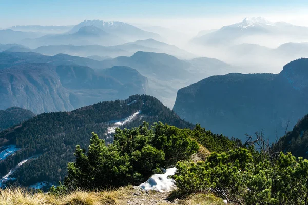 Espectacular vista de siluetas cordilleranas y niebla en valles. Vista desde la cima del monte Corno di Tres, Tresner Horn hasta Cima Paganella. Trentino, Tirol del Sur, Alpes, Italia . — Foto de Stock