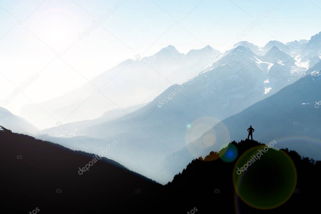 Spectacular mountain ranges silhouettes. Man reaching summit enjoying freedom. View from Top of Mount Corno di Tres, Tresner Horn. Trentino, South Tyrol, Alps, Italy.