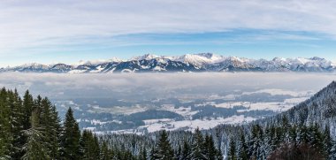 Karlı dağ sırasının sisli bulut katmanının üzerindeki inanılmaz panoramik manzara. Rangiswangerhorn 'dan Illertal, Allgau, Bavyera, Almanya.