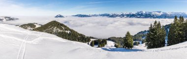 Kar dağından karlı dağ sırasına kadar sisli bulut katmanının üzerindeki inanılmaz panoramik manzara. Bulutlar denizi. Rangiswangerhorn, Allgau, Bavyera, Almanya.