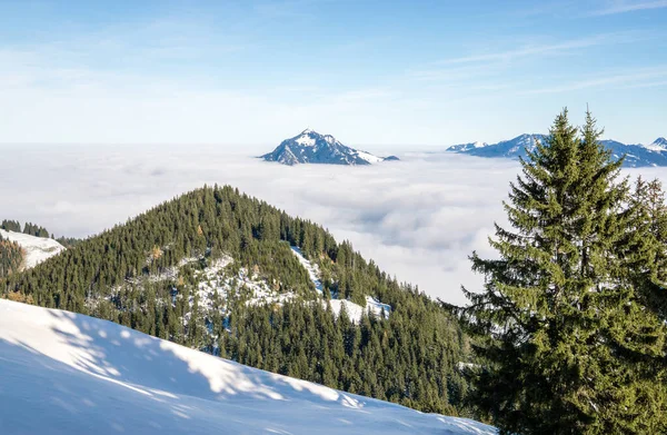 Incredibile vista dalla montagna delle nevi alla catena montuosa innevata sopra lo strato di nuvole nebbiose di inversione. Sopra le nuvole su Rangiswangerhorn, Allgau, Baviera, Germania. — Foto Stock