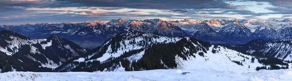 Soğuk kış günbatımında, kar, dağ sıralarını ve dramatik gökyüzünü muhteşem bir şekilde kaplıyor. Riedberger Boynuzu 'ndan Allgau Alp Dağları' na bakın. Bavyera, Almanya. — Stok fotoğraf