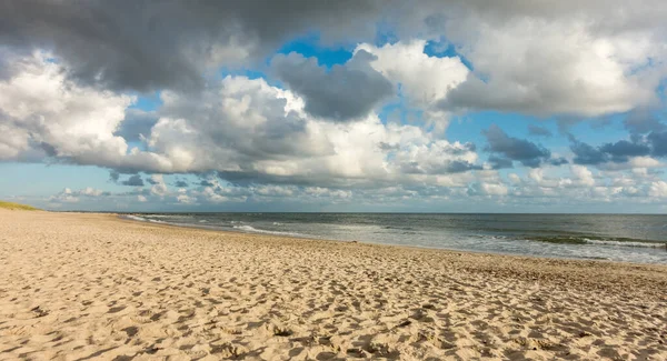 푸른 하늘과 온화 한 저녁 햇살을 받으며 해안선에는 극적 인 구름이 끼어 있는 해변 모래가 있다. Hvidbjerg Strand, Blavand, North Sea, Denmark. — 스톡 사진