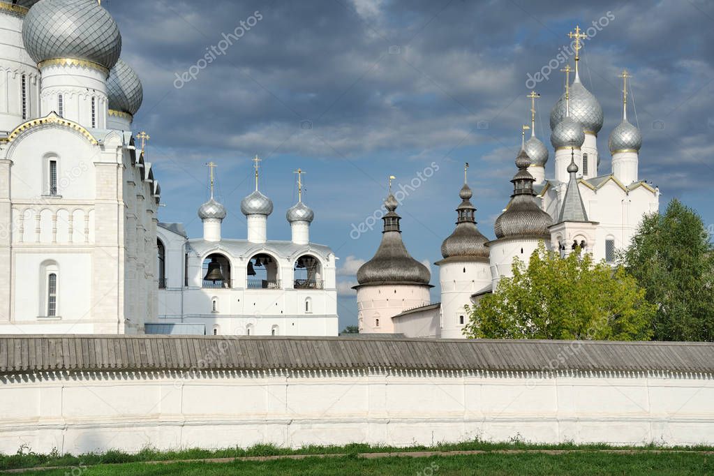 ROSTOV VELIKIY, RUSSIA - Beautiful onion cupolas (domes) of ancient churches and towers of the architectural ensemble of Rostov Kremlin behind the low wall surrounding the Cathedral Square (one of three parts of the Kremlin).