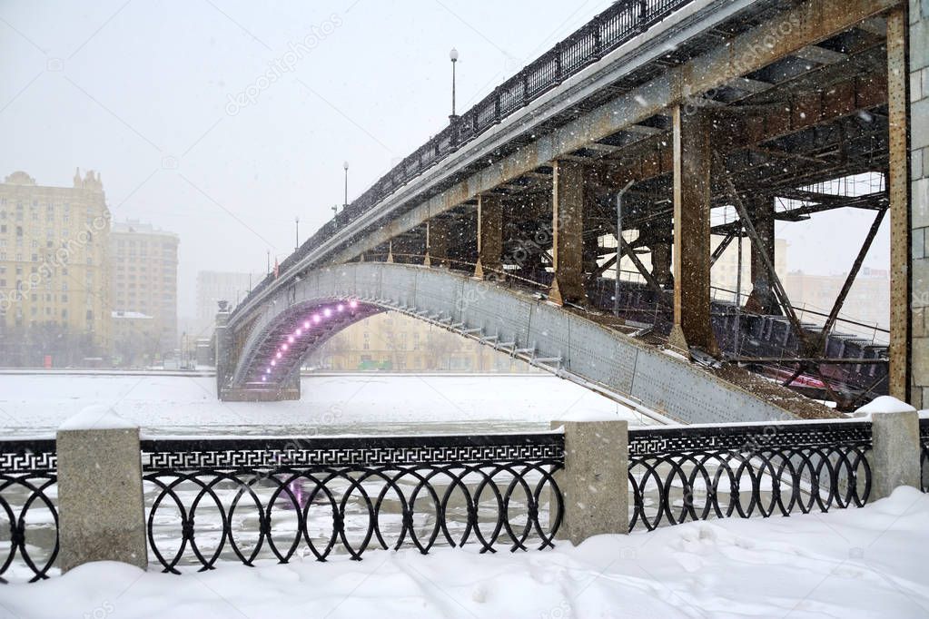 MOSCOW, RUSSIA - Jan 26, 2019Angle view at the steel arch Smolensky Metro Bridge that spans Moskva River in Dorogomilovo District of Moscow during the massive snowfall in afternoon.