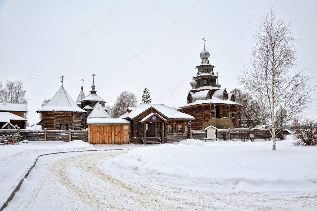 SUZDAL, VLADIMIR REGION, RUSSIA -View from Pushkarskaya street on beautiful wooden churches and entrance into the Suzdals Museum of Wooden Architecture framed by a birch tree in winter.
