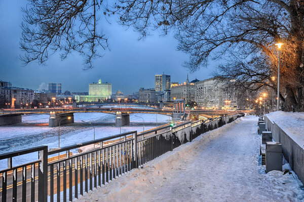 MOSCOW, RUSSIA - Twilight view of frozen Moskva River, Borodino Bridge (Borodinsky Most), House of Government of Russian Federation (White House) from a small park at 7th Rostovskiy lane.