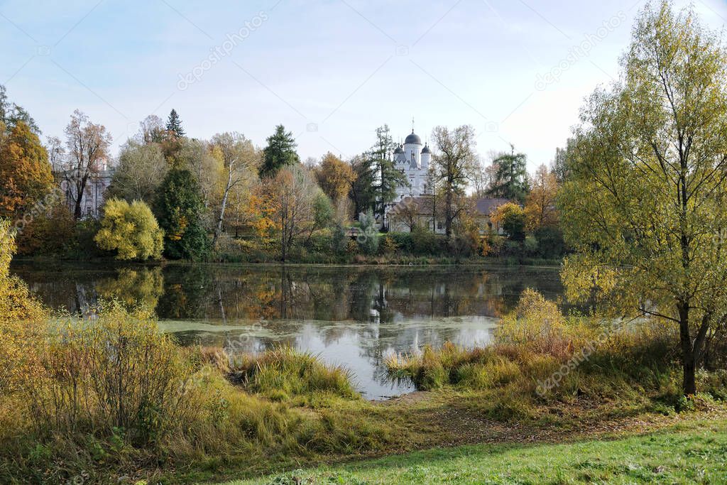 Beautiful Autumn scenery with the view from Golitsino park of Heroes of 1812 on the estate with old Church of Transfiguration (1590s) in Bolshie Vyazemy settlement with reflections at Vayzemka River