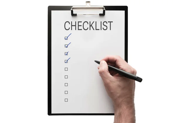 Top view of hand with pen on clipboard with checklist on white background — Stock Photo, Image