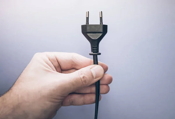 male hand holding electric plug
