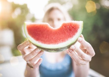 bir dilim sulu taze karpuz tutan sarışın kadın