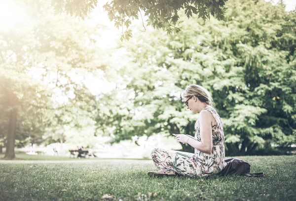 Mujer usando smartphone en parque público — Foto de Stock