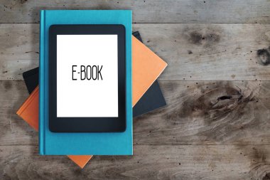 e-kitap okuyucu bir rustik ahşap masa kavramı kitap yığını üzerinde