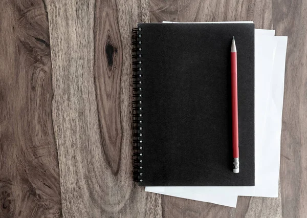 Cuaderno espiral negro y pluma sobre mesa de madera —  Fotos de Stock