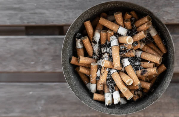 Вид сверху на концы сигарет и пепел в грязной пепельнице — стоковое фото