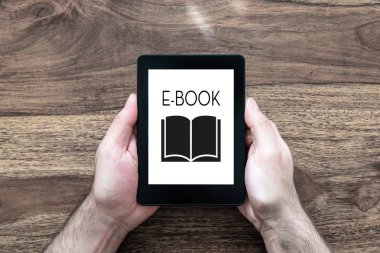 e-kitap okuyucu rustik ahşap masa üzerinde tutan adam