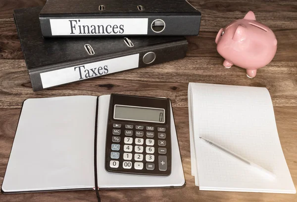 Financiën en belastingen concept met Ringmappen, piggy bank en calculator op houten tafel — Stockfoto