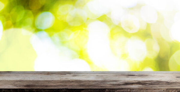 wooden table against lush green bokeh summer or spring background