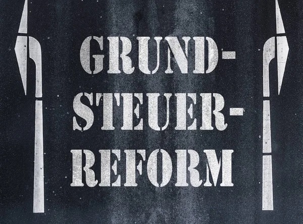 Palabra alemana Grundsteuerreform property or land tax reform written on asphalt — Foto de Stock