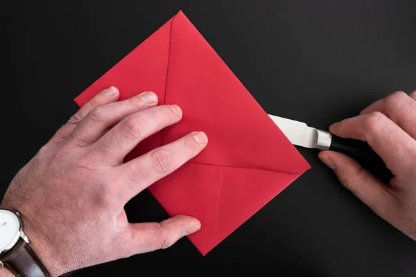 Mani di uomo aprendo busta rossa con coltello di carta — Foto Stock