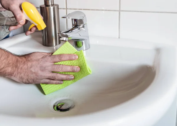 Pessoa limpeza pia do banheiro com pano de esponja — Fotografia de Stock