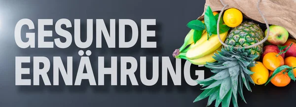 Слова Gesunde Ernahrung, німецька для здорової їжі або здорового харчування, з свіжі фрукти в паперовий мішок — стокове фото