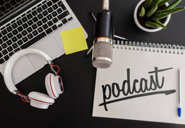 Podcast kayıt kavramı mikrofon, kulaklık ve dizüstü bilgisayarın yanına Not Defteri ile
