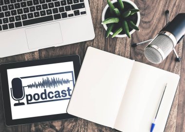 Podcast kayıt cihazları ahşap masa üzerine tablet ekranında podcast logolu Üstten Görünüm