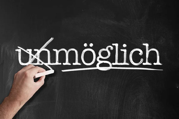 Changing word unmoglich to moglich, German for impossible and possible, on blackboard — Stock Photo, Image