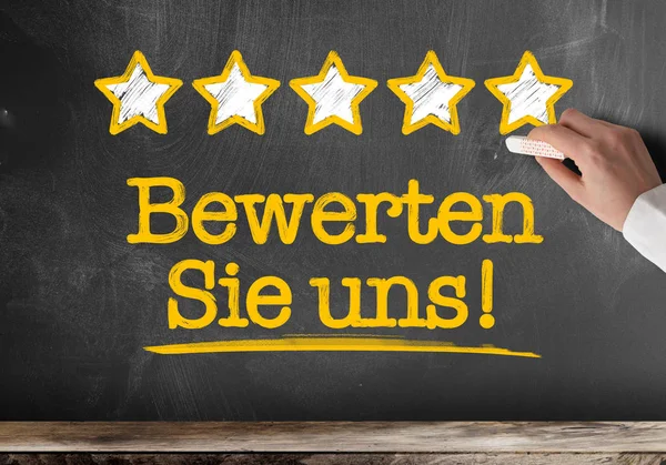 text BEWERTEN SIE UNS, German for rate us or rate our service, written on blackboard with five golden stars