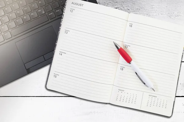 Open calendar or planner and pen on laptop computer — Stock Photo, Image