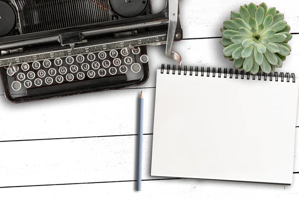 Alte Schreibmaschine, leerer Notizblock und Bleistift und saftige Pflanze auf rustikalem weißem Holztisch — Stockfoto