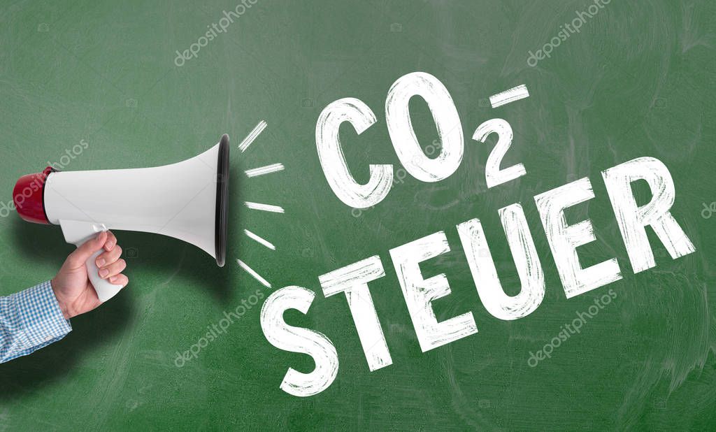 hand holding megaphone or bullhorn against chalkboard with text CO2-STEUER, German for carbon tax