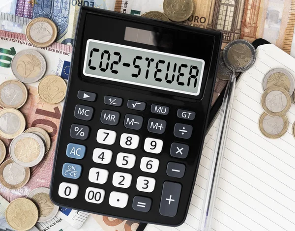 Text co2 steuer, deutsch für CO2-Steuer, Taschenrechner gegen Euro-Scheine auf dem Tisch — Stockfoto