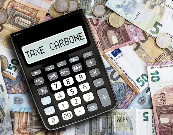 Text TAXE CARBONE, franceză pentru taxa pe carbon, pe afișarea calculatorului de buzunar față de facturile la euro pe masă — Fotografie, imagine de stoc