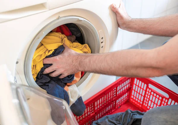 Férfi betöltése színes ruhák mosógép — Stock Fotó