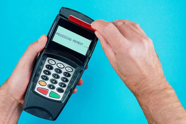 person swiping credit card or debit card through POS payment terminal
