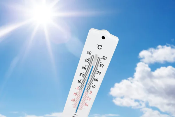 Thermometer tegen blauwe zomerhemel en zon — Stockfoto