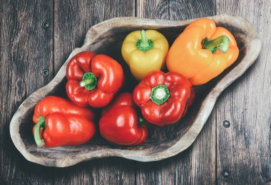 Masadaki ahşap kasede taze dolmalık biber.