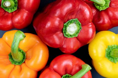 Kırmızı, turuncu ve sarı dolma biberlerin hemen üstünde.
