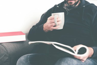 Kanepede dergi ya da günlük okuyan beyaz adamın yakın çekimi.