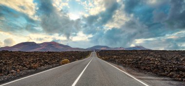 Lanzarote, Kanarya Adaları 'ndaki volkanik arazide uzun düz bir yol.