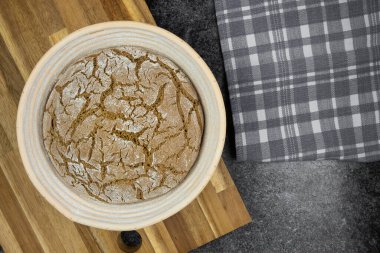 Banneton 'da mutfak tezgahında sade çavdar ekmeği kanıtı.