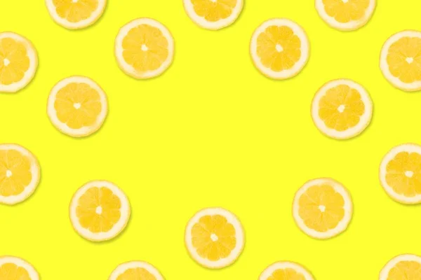 Colorful fruit frame. Lemon slices on a bright yellow background. Top view with copy space.