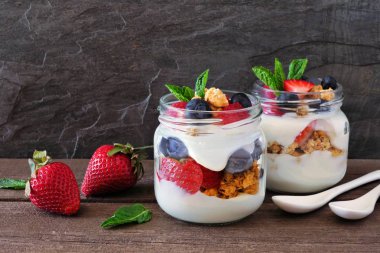 Çilek, yaban mersini ve ahududu gezegendeki mason kavanoz. Yan görünümü olay yerine koyu arka plan.