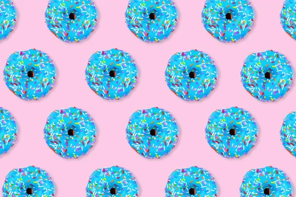 Colorful food pattern. Soft blue iced  donuts on a pastel pink background. Top view.