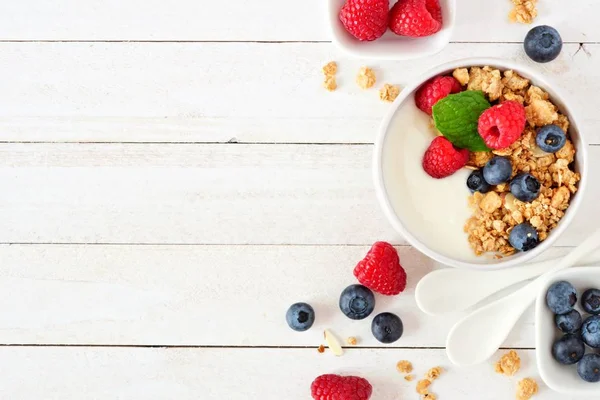 健康酸奶与覆盆子 蓝莓和燕麦 以上视图 侧面边框在白色的木材背景 复制空间 — 图库照片