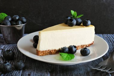 Cheesecake yaban mersini ile dilim. Sahne karanlık bir arka plan ile kapatmak.